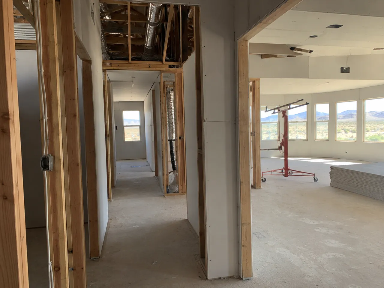 Tall stairwell drywall being hung and taped in a new-construction home